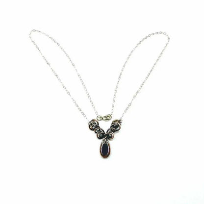 Silver and Copper Wire Sculpted Purple Crystal Drop Necklace showcasing a beautiful purple crystal drop with unique wire design.