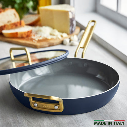 Blue frypan with gold handles on counter beside bread, cheese, and garlic; 12-inch size visible.