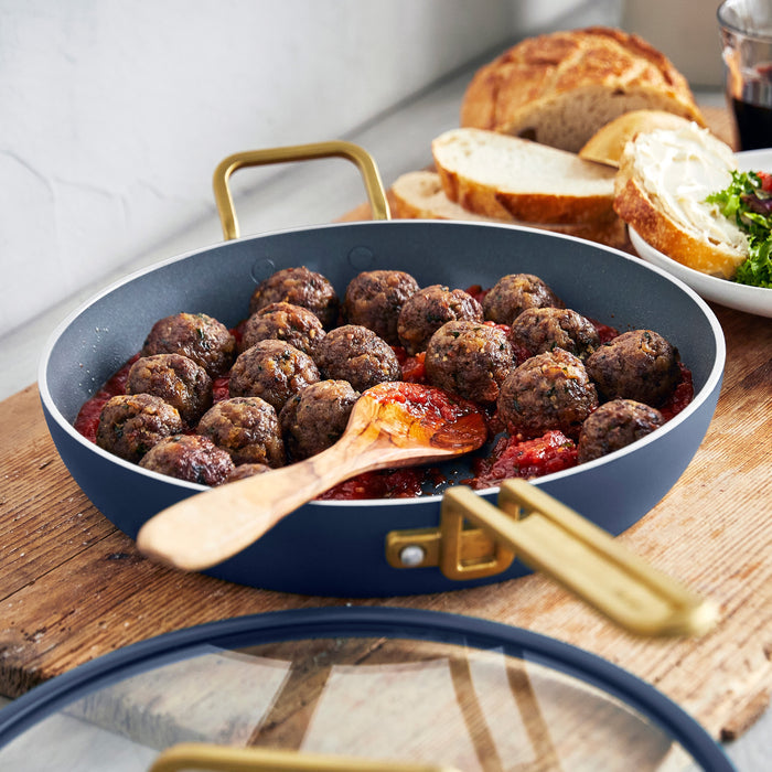 Stanley Tucci ceramic nonstick 12-inch frypan with meatballs in tomato sauce, bread, and salad on wood table.