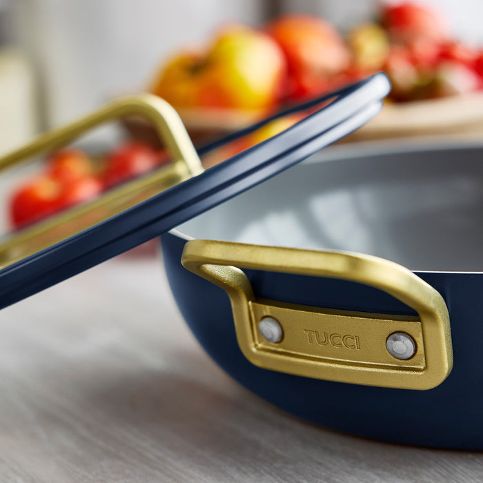 Marino Blue ceramic 4.5-quart pan with gold handles shown close up.