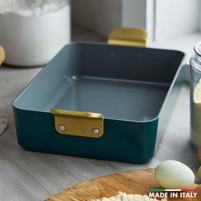 Ceramic lasagna pan in Venetian teal with gold handles, set on a kitchen counter.