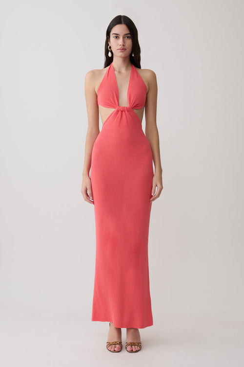 Woman wearing a coral halter knit maxi dress.