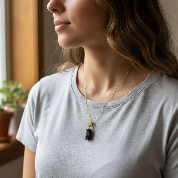Wire Wrapped Raw Black Tourmaline Gemstone Necklace worn by a woman in a casual gray t-shirt.